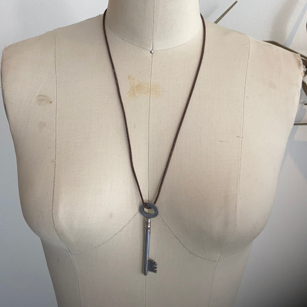 Vintage key necklace on brown leather cord.